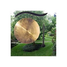 a large gong hanging from the side of a tree