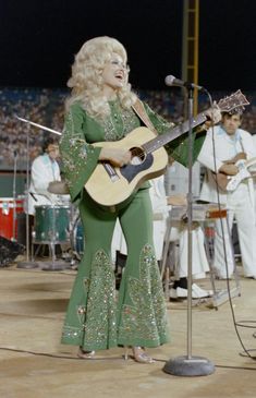 dolly monroe singing at a concert with her guitar