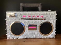 an old fashioned boombox with fringes and mirrors on it's sides sitting on a wooden table