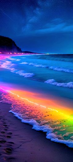 a rainbow colored beach with waves coming in to shore and the sky filled with stars