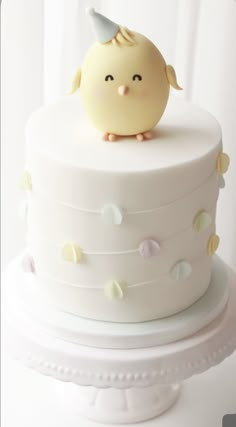 a white cake with a yellow bird on top