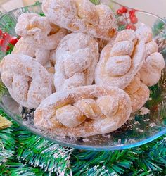 a glass bowl filled with powdered donuts on top of a green christmas tree