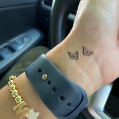 a small wrist tattoo with two butterflies on it