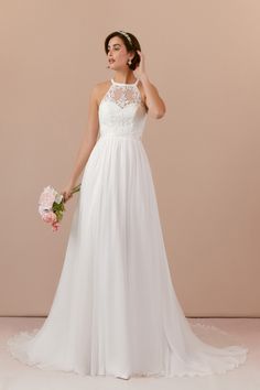 a woman in a white wedding dress holding a bouquet