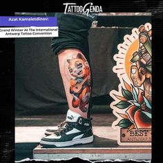 a person with tattoos on their legs standing next to a sign that says tattoo genda