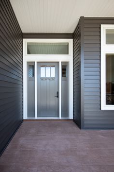 the front door of a house with two windows on each side and an entry way leading to another room