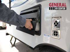 a person is pressing the button on an rv's fueling station that has been converted into a recreational vehicle