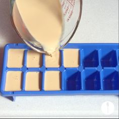 someone is pouring milk into an ice tray