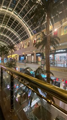 an indoor mall with palm trees and shops