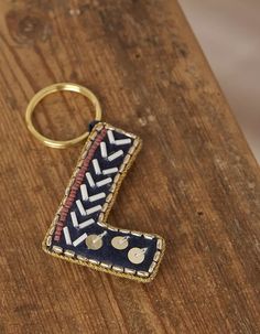 a wooden table with a keychain on it and a letter shaped like an arrow