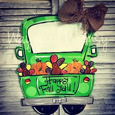 a green bus with the words happy fall written on it and some pumpkins in the back