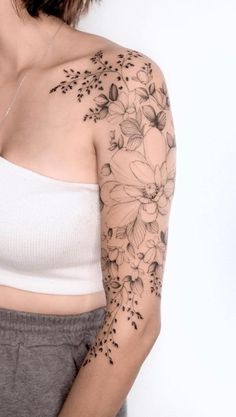 a woman with a flower tattoo on her arm and shoulder is posing for the camera