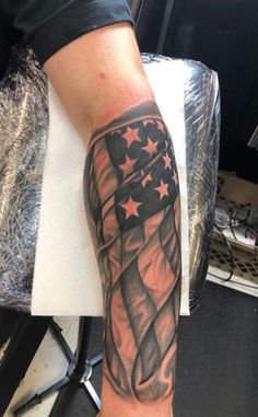 a man's arm with an american flag and stars tattoo on the side of his arm