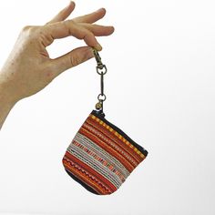 Colorful, handmade, coin purse made from vintage Hmong Tribe textiles. Attached to a brass keychain clip, each one-of-a-kind coin purse is handmade by Na and Pha in northern Thailand. These bright little purses have sturdy cotton lining, a zippered pouch, tiny bell on the pull, and keychain clip that helps you keep track of it and allows you to clip it anywhere you wish (we are thinking these will make adorable Christmas tree decorations!). This lovely Hmong couple seek out only the most beautif Bohemian Handmade Coin Purse For Travel, Handmade Bohemian Rectangular Coin Purse, Bohemian Pouch Coin Purse, Traditional Multicolor Pouch Coin Purse, Handmade Multicolor Bohemian Coin Purse, Brass Keychain, Open Door Policy, Hmong Textiles, Keychain Clip