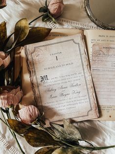 an old fashioned wedding program and flowers on a white sheet with a mirror in the background