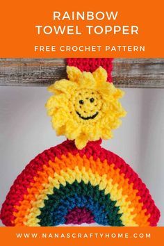 a crocheted rainbow towel topper with a smiling face on it's back