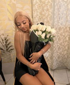 a woman is sitting on a chair with flowers in her lap and holding a bouquet