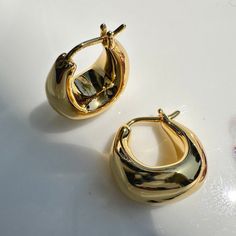 Meet your new everyday staple: our chubby Dumpling Hoops. Charming on their own, or as a SUPER cute addition to your ear stack. Measures 16mm x 16mm. Our materials make for an amazing, high quality, seamless, jewelry piece with longevity. Our earrings are plated with 18k gold, 18k rose gold, or rhodium and finished with a protective coating. A little secret we’ll keep between us: it looks way more than it costs. Chunky Gold Earrings, Open Hoop Earrings, Ear Stack, Between Us, Hammered Gold, Button Earrings, Huggie Hoop Earrings, Accessories Jewelry Earrings, Charm Gift