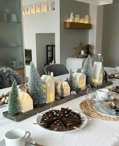 a table topped with cakes and desserts next to a christmas tree filled window sill