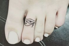 a woman's toe with an eye tattoo on it