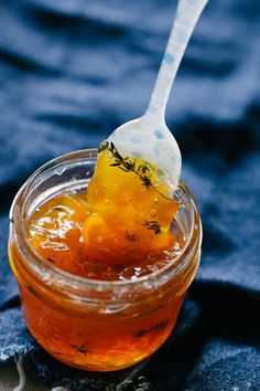 a spoon full of honey sitting in a jar