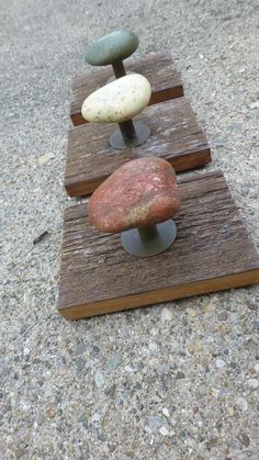 three rocks sitting on top of wooden boards