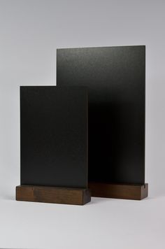 two black square shaped objects on wooden bases