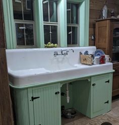 a kitchen with green cabinets and a white sink