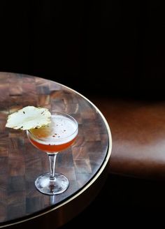 a small glass filled with liquid on top of a wooden table