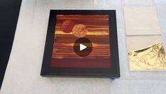 an art project is being displayed on a table with gold foil and other items around it