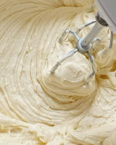 a mixer is mixing cream in a bowl