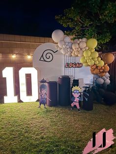 balloons and decorations are set up on the lawn for an outdoor birthday party at night