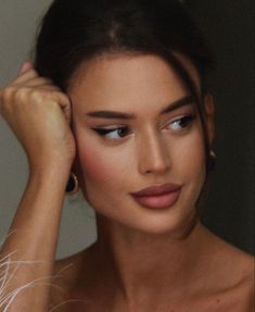 a close up of a woman with her hand on her head