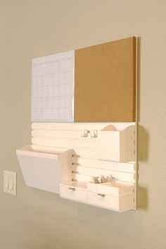 there is a bulletin board on the wall with drawers in front of it and a clipboard attached to the wall