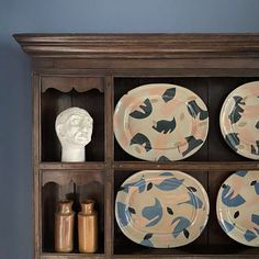 a wooden shelf with plates and vases on it