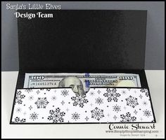 a black and white christmas themed business card holder with money sticking out of it's side