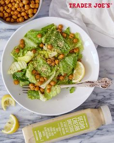 plate of vegan Caesar salad on a marble background next to a bottle of TJ's Vegan Caesar Dressing Vegan Ceasar Dressing, Vegan Caesar Salad Dressing, Restaurant Classic, Vegan Caesar Dressing, Trader Joes Vegan, Vegan Caesar Salad, Vegan Caesar, Garbanzo Bean, Joe Recipe