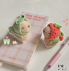 two crocheted animals sitting on top of a notebook