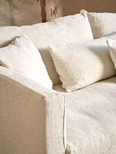 a white couch with four pillows on it's back and one arm folded down