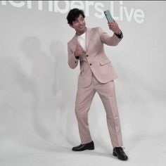 a man in a pink suit taking a selfie