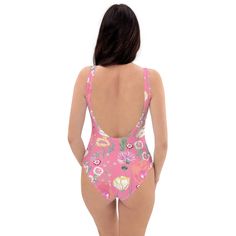 a woman in a pink floral print swimsuit with her back turned to the camera