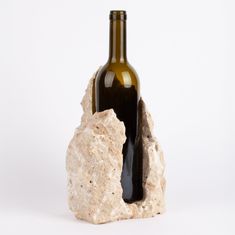 a bottle of wine sitting on top of a rock