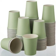 a stack of green cups sitting next to each other on top of a white table