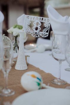 the table is set with wine glasses, plates and napkins for an elegant wedding reception