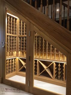 a wine cellar under the stairs in a house