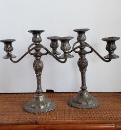 two metal candlesticks sitting on top of a wooden table