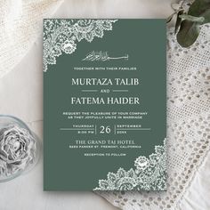 a wedding card with an elegant lace design on the front and back, sitting next to a flower