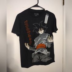 This Dragon Ball Z T-Shirt For Men Is A Must-Have For All Fans Of The Anime. The Shirt Features A Short Sleeve Design And Is Made From 100% Cotton For Maximum Comfort. It Is Also Machine Washable For Easy Care. The Black Shirt Is Adorned With The Iconic Dragon Ball Z Logo And Is Available In Size Xs. The Regular Fit Makes It Suitable For Most Body Types, And The Shirt Is Perfect For Casual Wear. This Shirt Is New With Tags And Is An Authentic Toei Animation Product Made In Mexico. Show Off Your Love For Dragon Ball With This Stylish T-Shirt Black Streetwear Shirt With Character Print, Black Tops With Front And Back Print For Fans, Black Short Sleeve Fan Apparel Shirt, Black Shirt With Front And Back Print, Relaxed Fit, Black Short Sleeve Shirt With Front And Back Print, Black Short Sleeve Shirt With Front Print, Casual Black Shirt With Character Print, Black Short Sleeve Fan Merchandise Tops, Black Graphic Tee Fan Merchandise Shirt