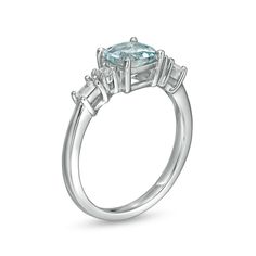 a ring with an aqua blue topazte surrounded by three baguettes in white gold