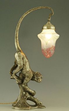 a lamp with a monkey on it and a glass shade hanging from the ceiling above